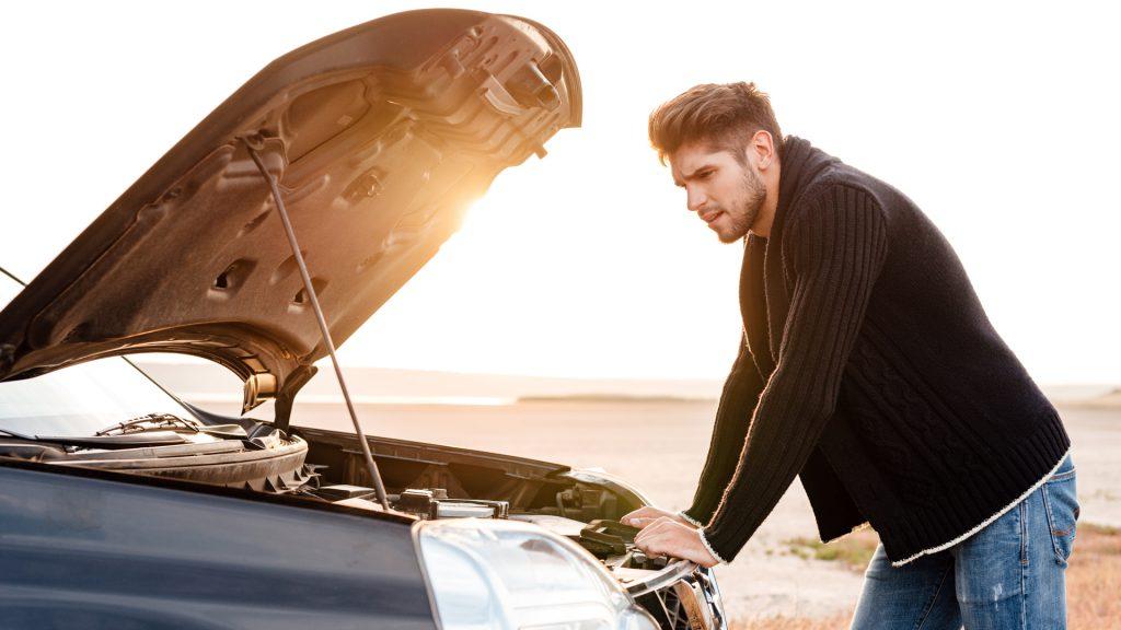 شخصی در حال نگاه به کاپوت خودرو